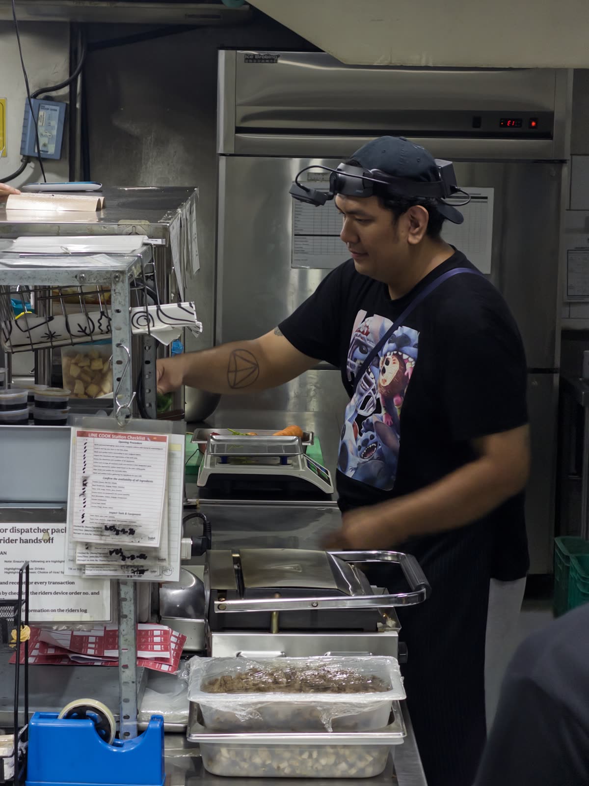 A Luckey collector wearing a head-mounted camera while preparing food in a commercial kitchen