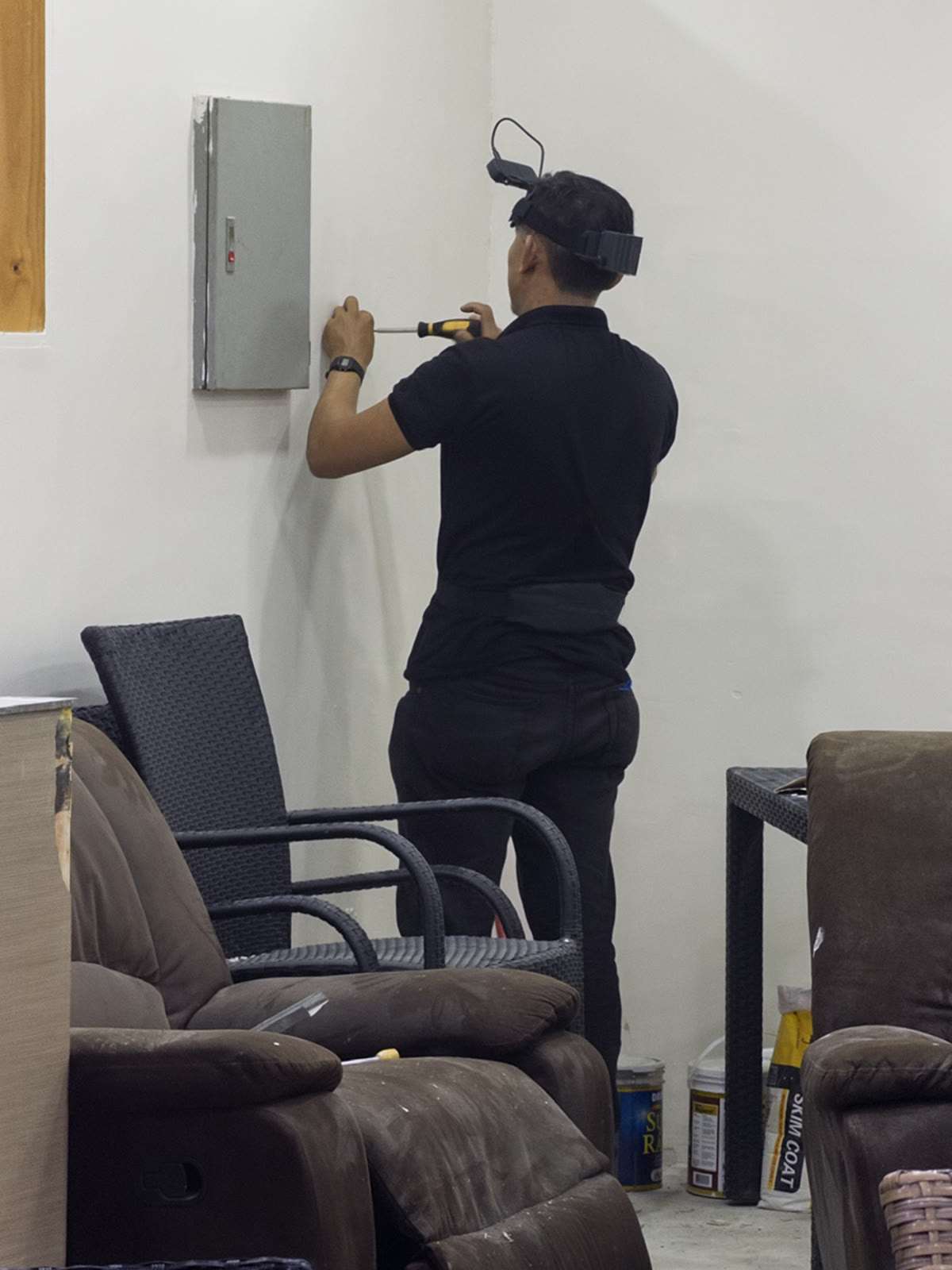 A Luckey collector wearing a head-mounted camera while using a screwdriver during facility maintenance