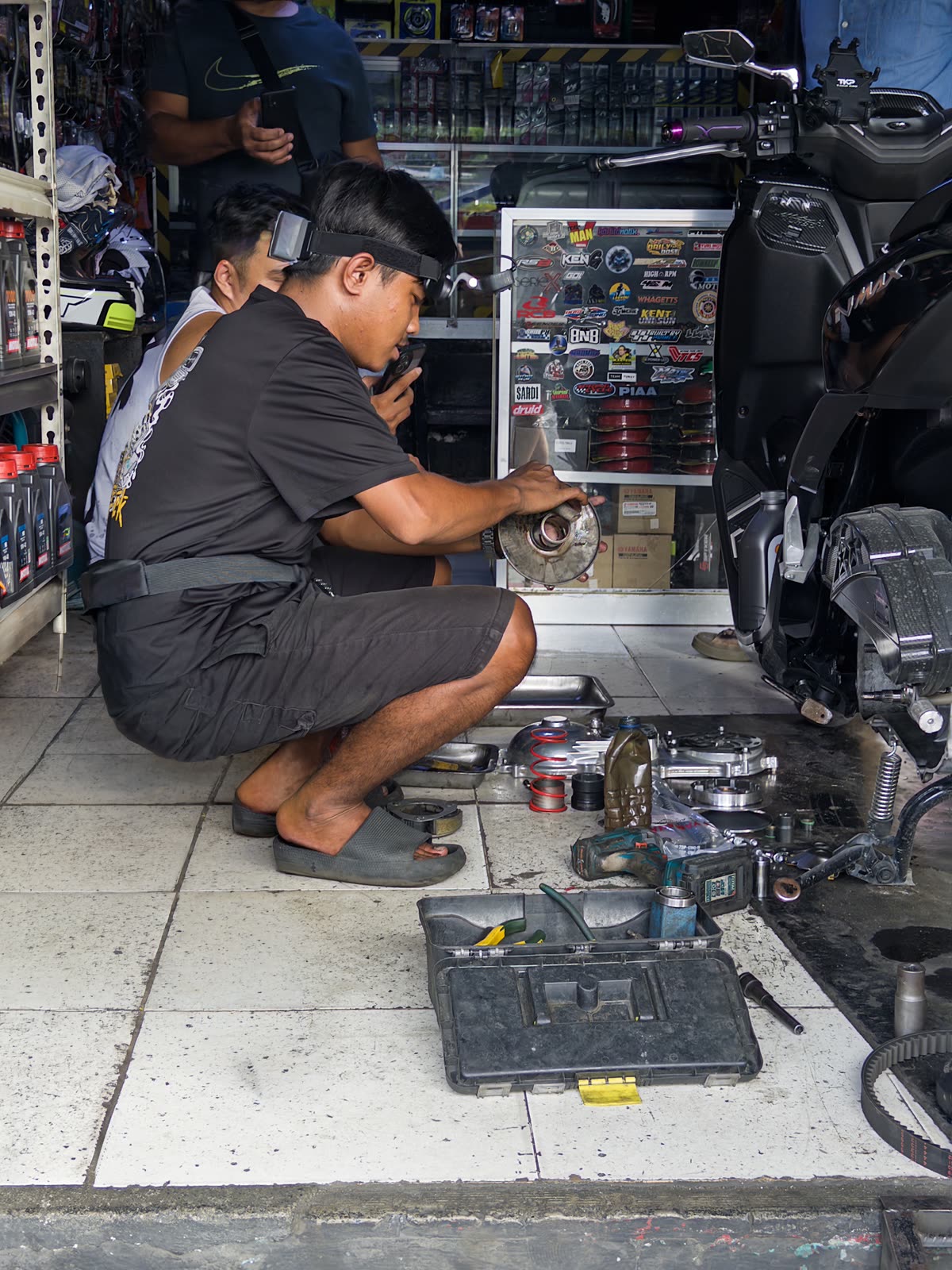 A Luckey collector wearing a head-mounted camera while repairing a motorbike